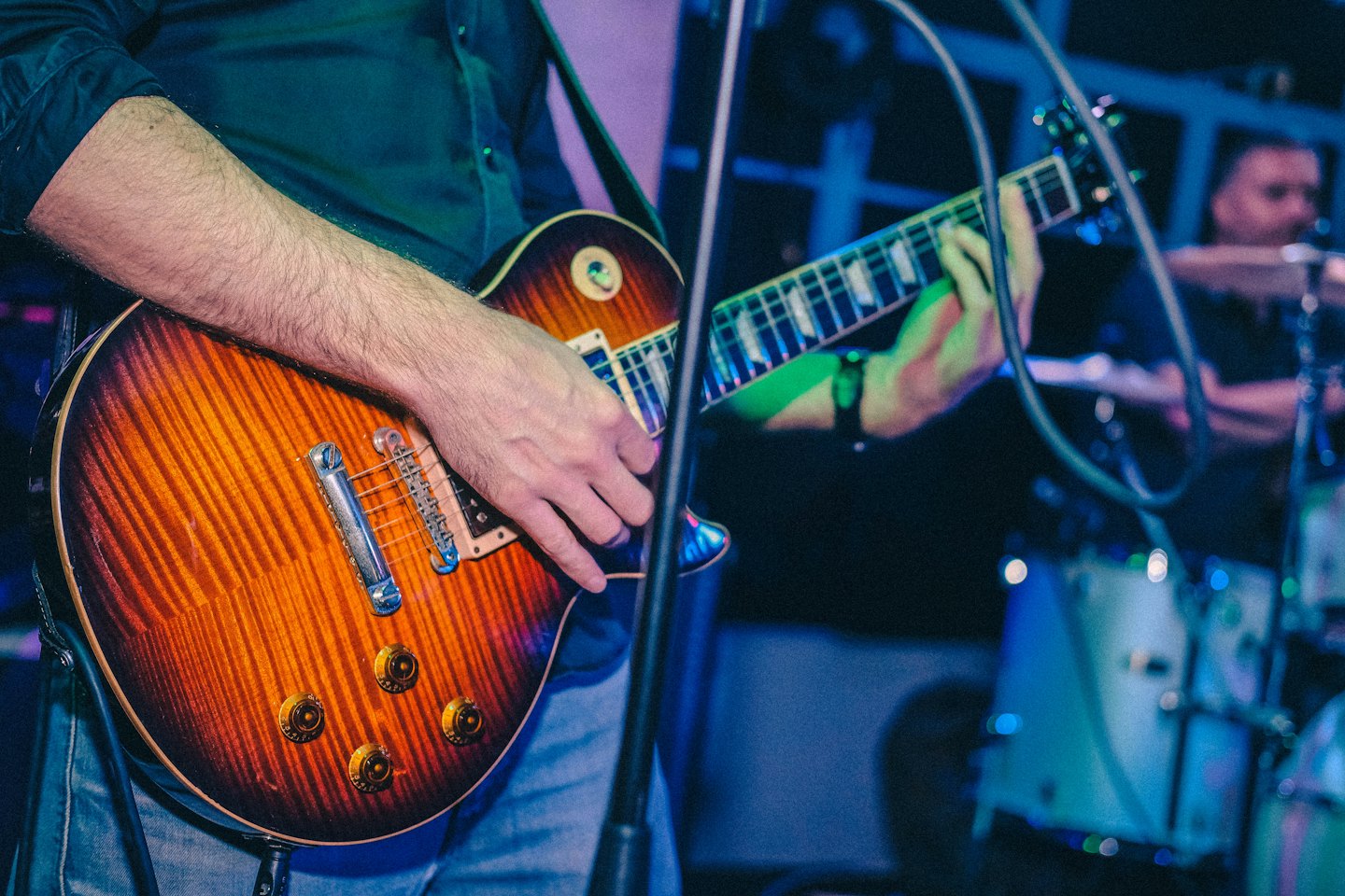 Een muzikant speelt een sunburst elektrische gitaar tijdens een live optreden.