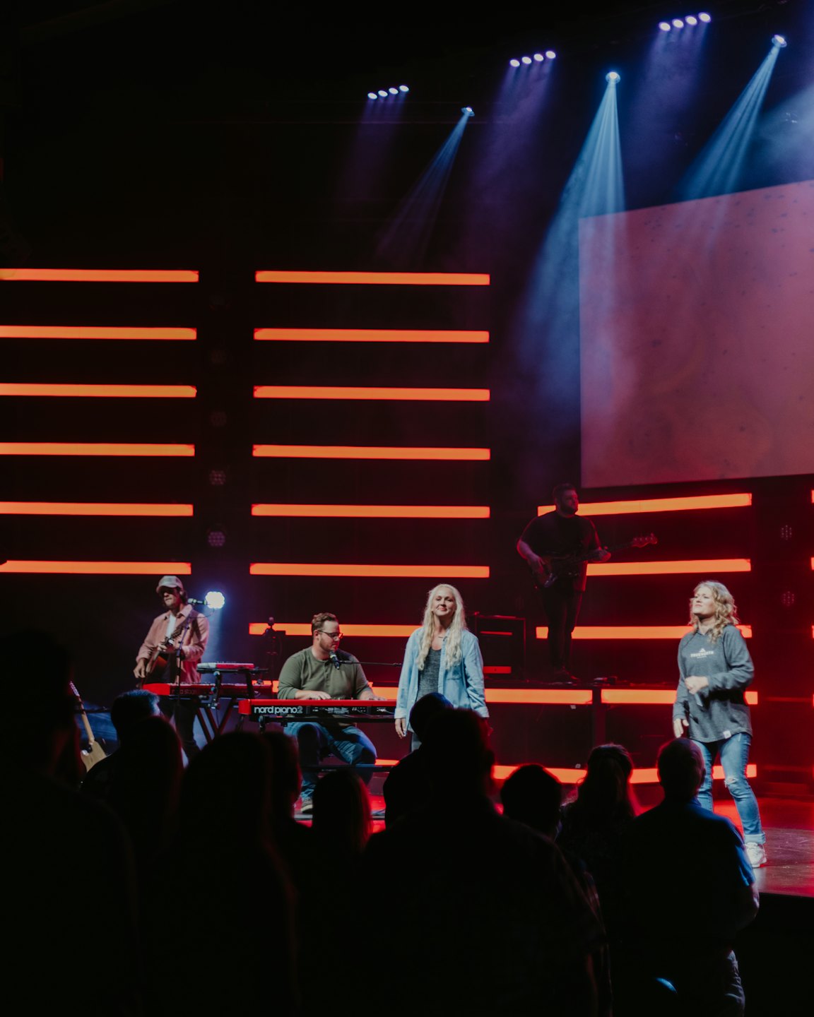Een live band treedt op op een podium met kleurrijke verlichting.